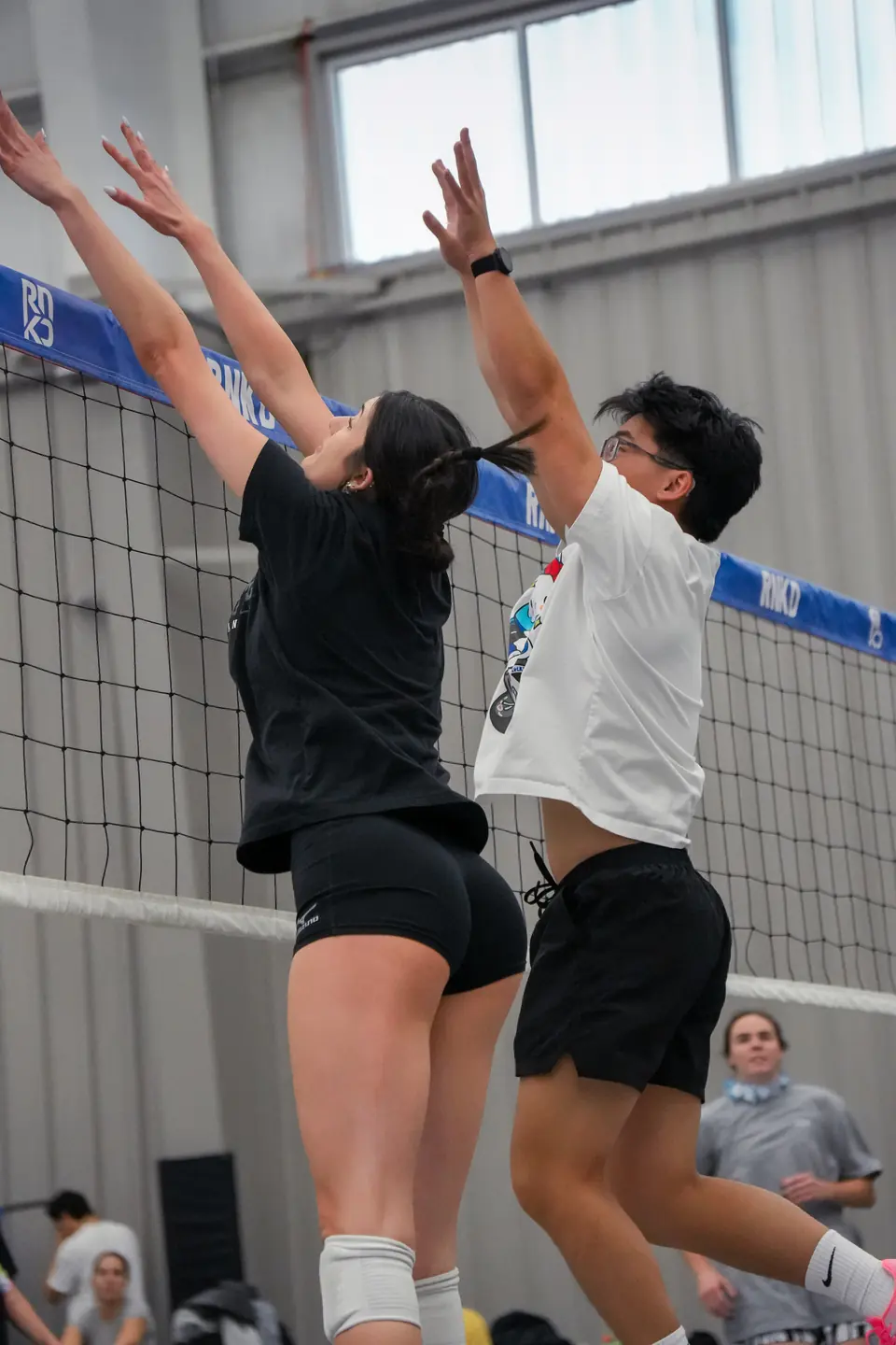 Two players going up together for a block at the net