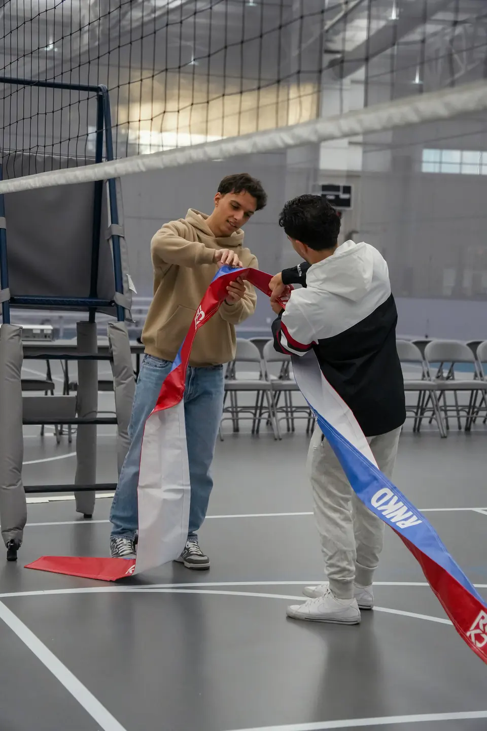 Two organizers unrolling RNKD net tape before check-in